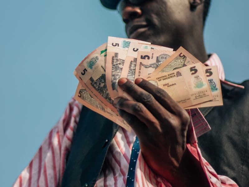 A man holding a fan of banknotes
